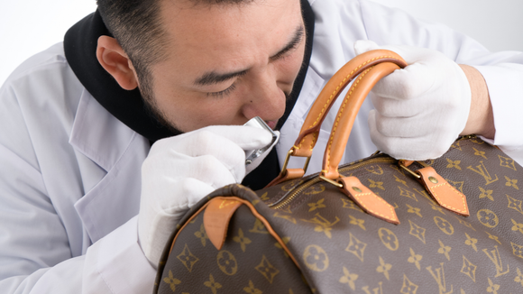Brand Street Tokyo authenticator examining a Louis Vuitton Monogram Speedy bag on a white surface