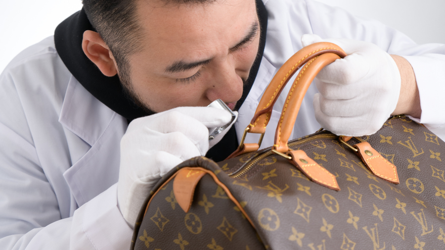 Brand Street Tokyo authenticator examining a Louis Vuitton Monogram Speedy bag on a white surface