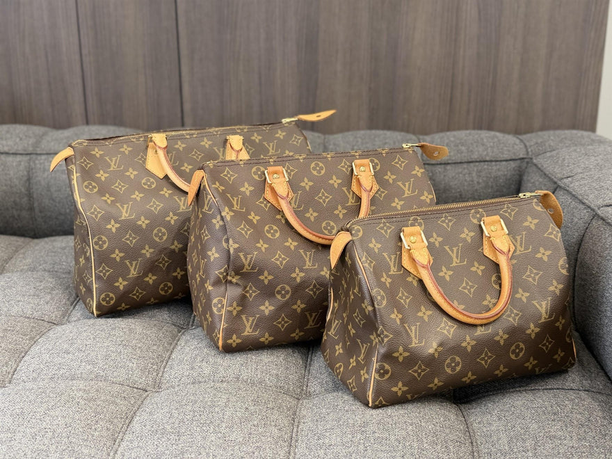 Three Louis Vuitton Monogram Speedy handbags in different sizes.